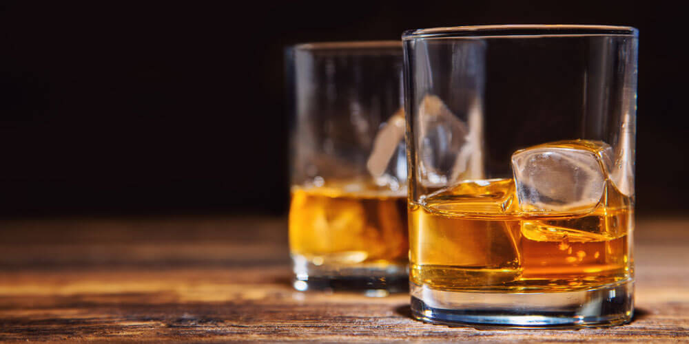 Zwei stilvoll gefüllte Gläser mit Brandy und Eiswürfeln